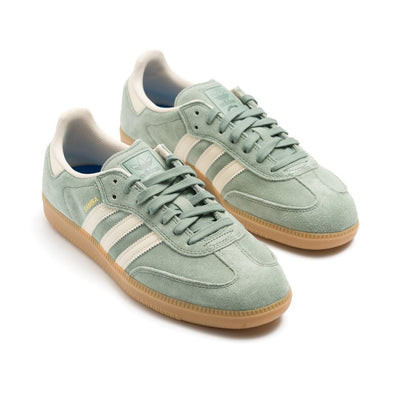 light green adidas samba adv with white stripes and a gum sole