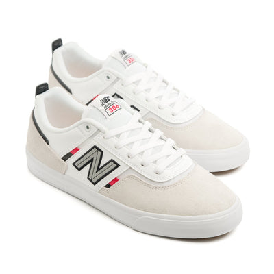 white men's new balance shoe with read and black details and a white sole