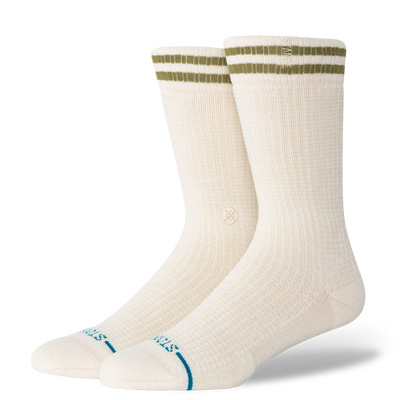 Pair of cream stance women's butterblend crew socks with green stripes on a white background