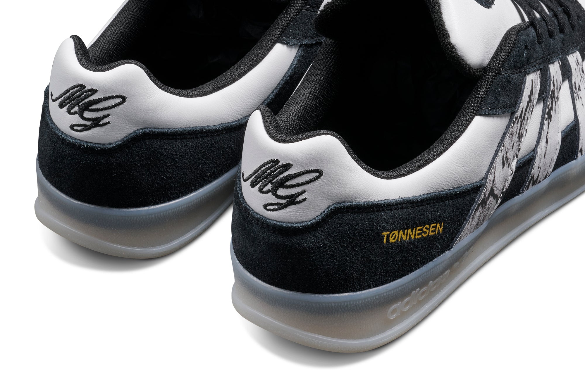 Black and white adidas x gustav tonnesen aloha sneaker with Adidas logo and a clear sole on a white background