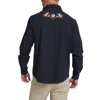 man wearing a howler dark navy western-style button-up shirt with embroidered eagle details on the shoulders and beige pants, photographed against a plain white background.