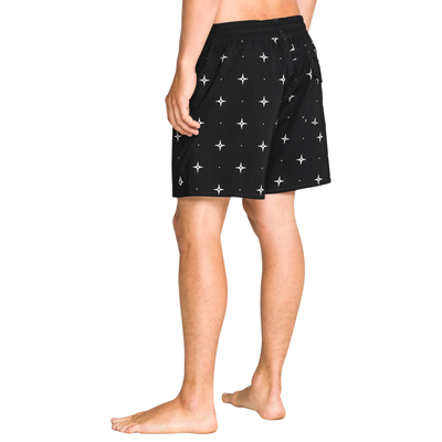 Man wearing black volcom lido swim shorts with star pattern on a white background