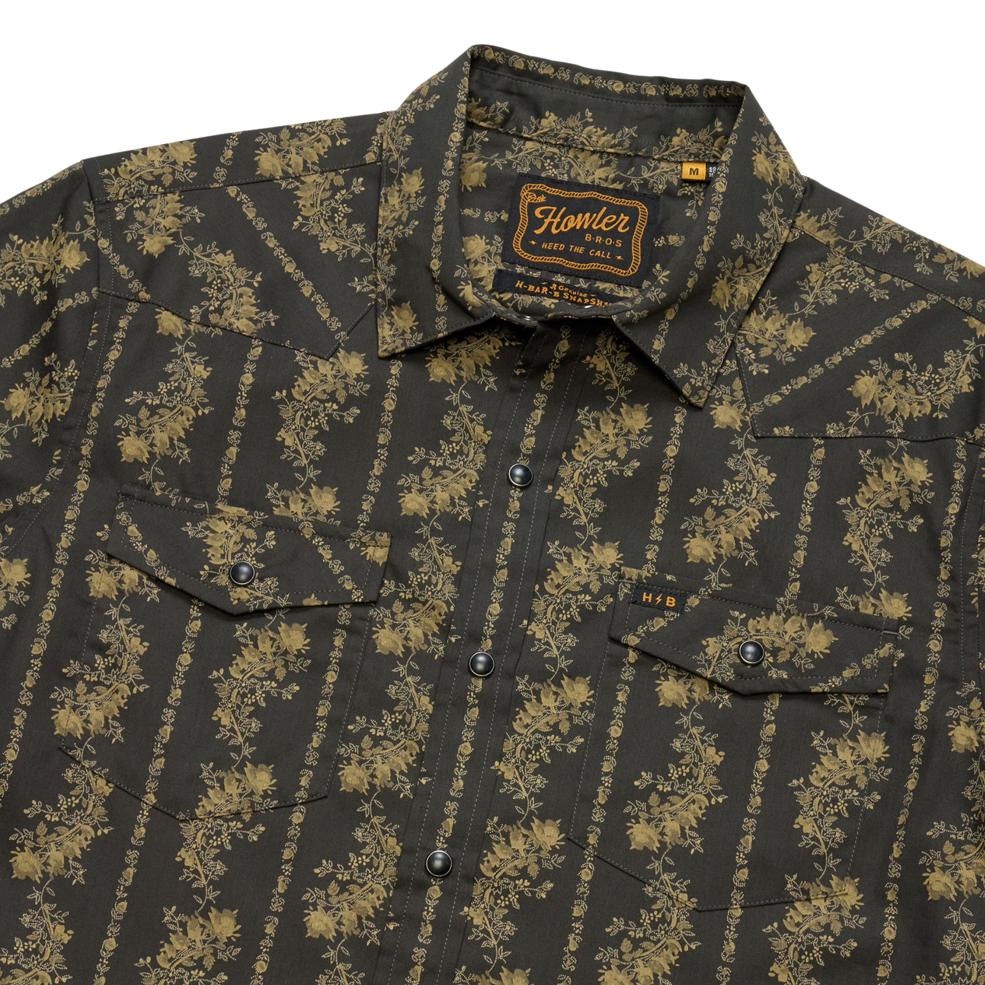close up of a Holwer Brothers H Bar B Snapshirt grampa's curtains in a black with a gold floral design on a white background
