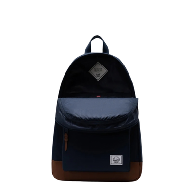 open Navy herschel heritage backpack with tan leather bottom and details on a white background