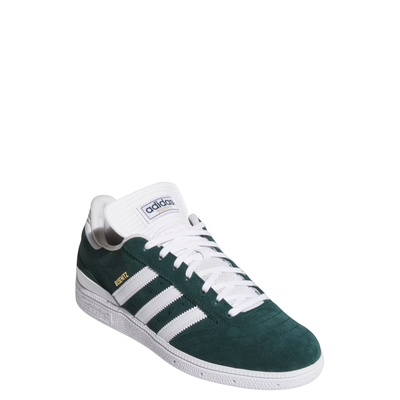 Green and white adidas busentiz skateboard sneaker with three white stripes on a light gray background