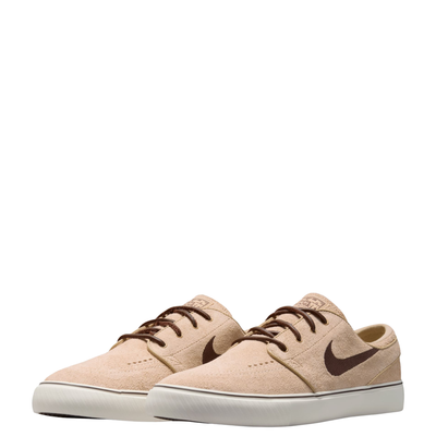 A Nike sb janoski low-top sneaker in a light beige suede and canvas mix, featuring a dark brown Swoosh logo, matching brown laces, and a thick white rubber sole.