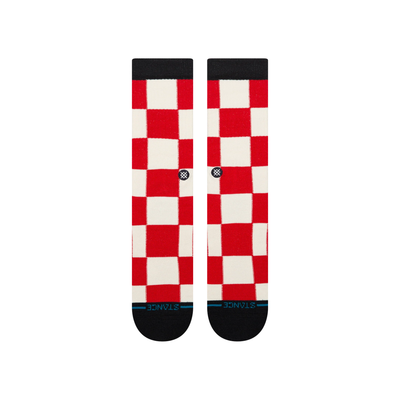 A pair of stance chaturanga crew socks with a red and white checkered pattern, featuring black cuffs, heels, and toes, and a small circular Stance logo on the side.