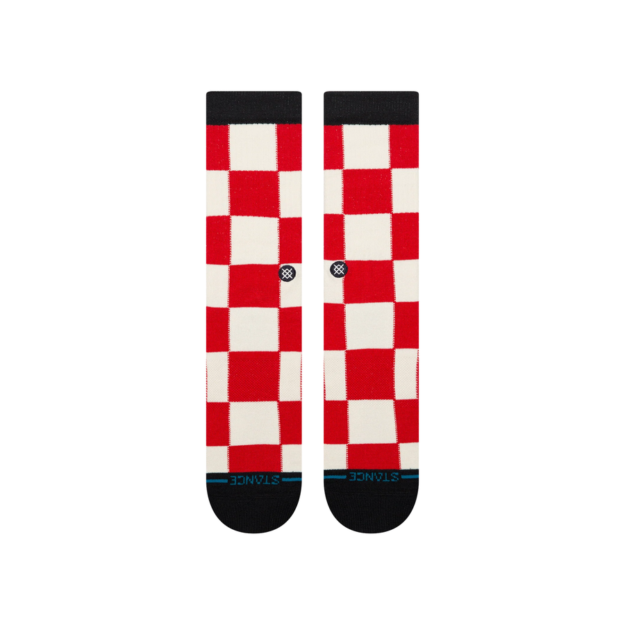 A pair of stance chaturanga crew socks with a red and white checkered pattern, featuring black cuffs, heels, and toes, and a small circular Stance logo on the side.
