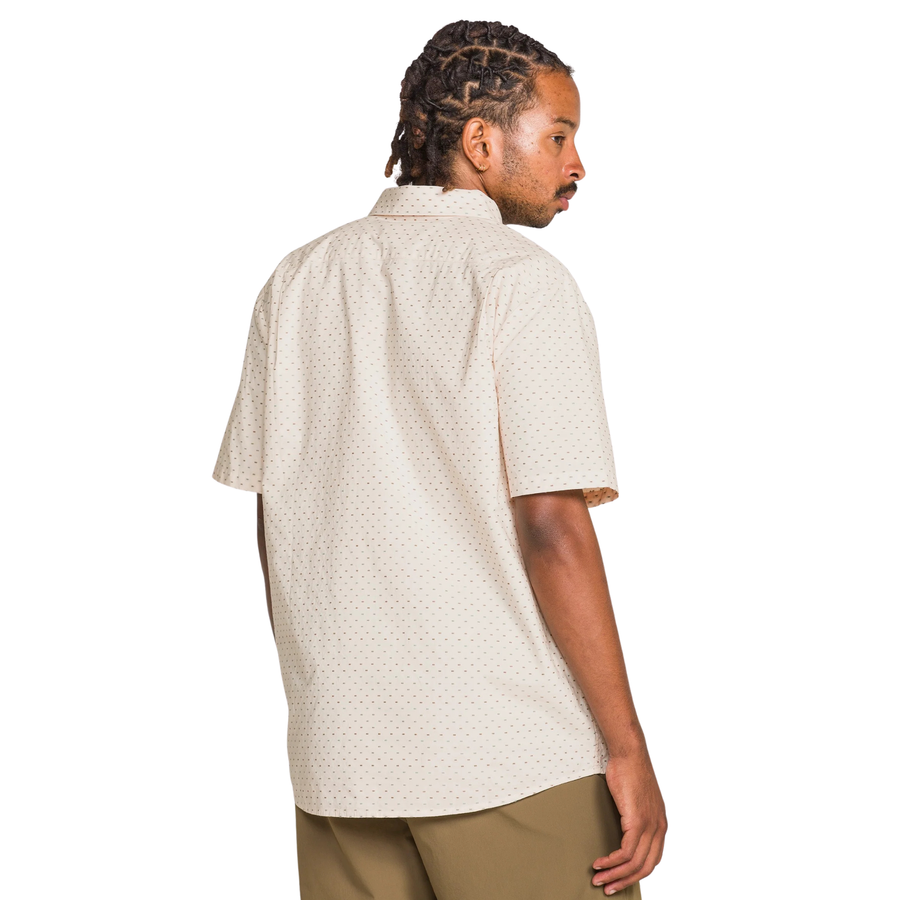 Man wearing a beige patterned volcom bankstone ii shirt on a white background