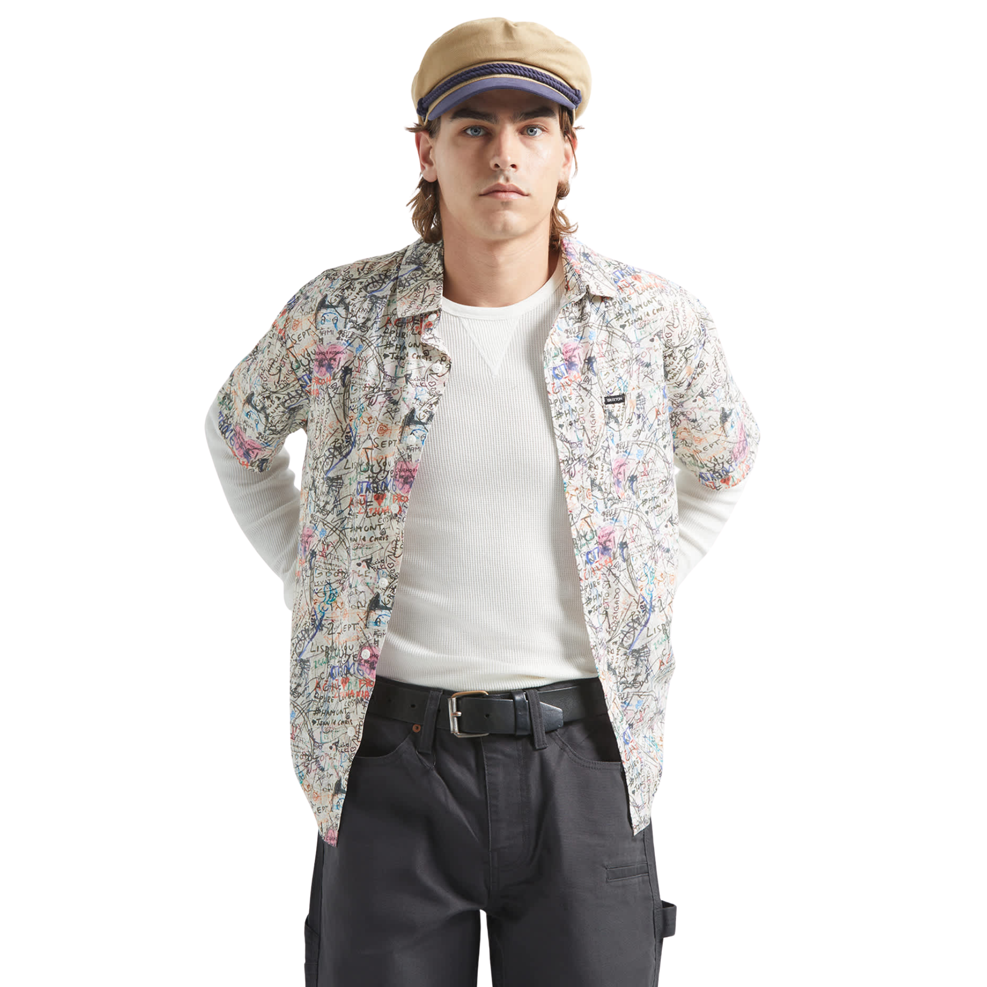 man wearing a brixton cru short sleeve woven shirt with graffiti pattern on a white background