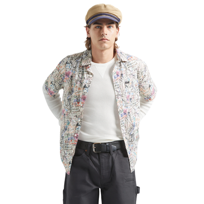 man wearing a brixton cru short sleeve woven shirt with graffiti pattern on a white background