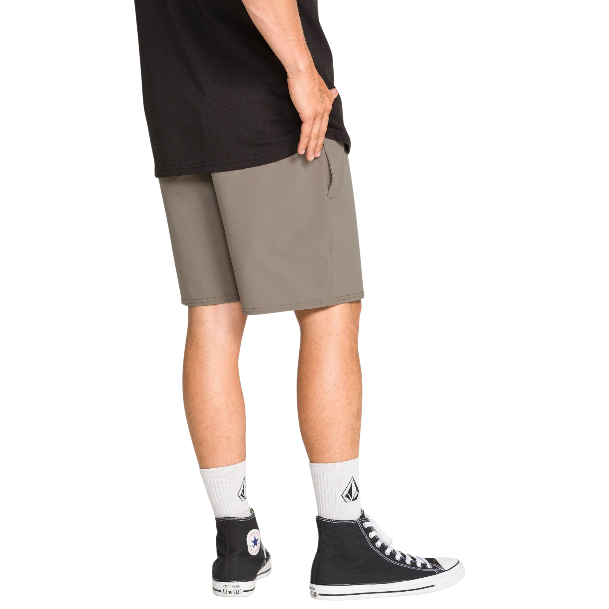 Man wearing a black tank top and TAN volcom nomaly elastic waist shorts on a white background