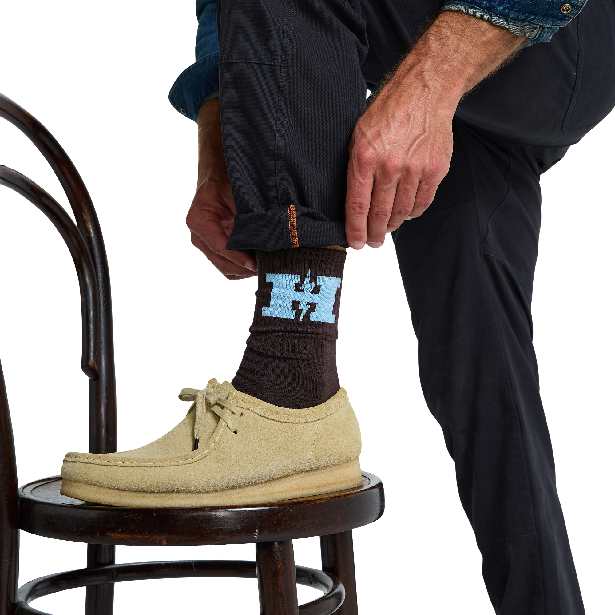 a person wearing a brown howler h-bolt socks with blue H and Howler Brothers in light blue