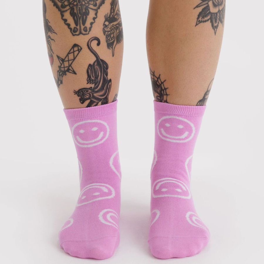pink baggu crew socks with white smiley faces on a white background
