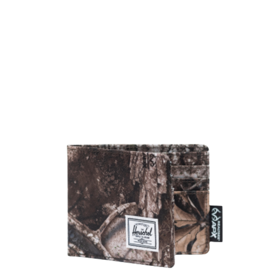 Camouflage-patterned real tree herschel roy wallet with a visible brand label on a white background