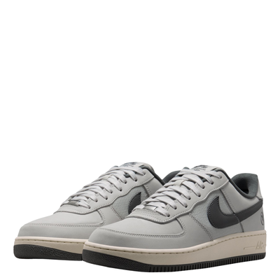 A pair of Nike sb x Yuto Air Force 1 Low skateboard sneakers in light gray and dark gray, featuring a light gray leather upper, dark gray Swoosh, and a cream midsole with a black outsole.