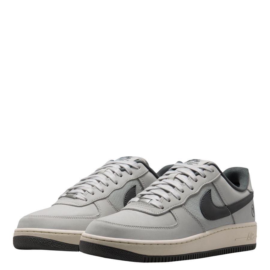 Nike sb x Yuto Air Force 1 Low skateboard sneakers in light gray and dark gray, featuring a light gray leather upper, dark gray Swoosh, and a cream midsole with a black outsole.
