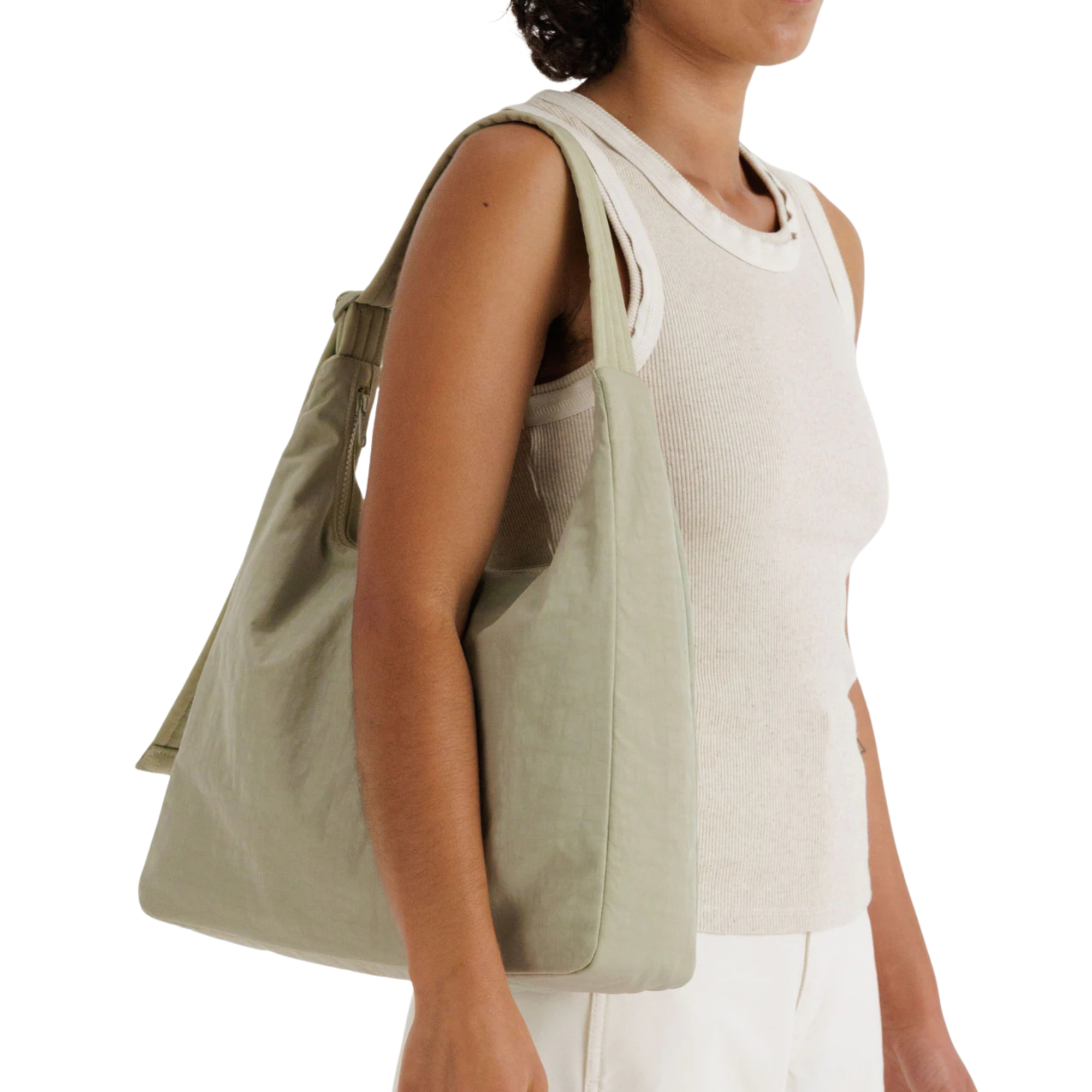 Person holding a light green baggu tote bag on a white background