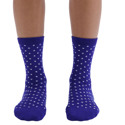 A pair of royal blue baggu crew socks with a white polka-dot pattern, shown on a person's feet against a plain white background.