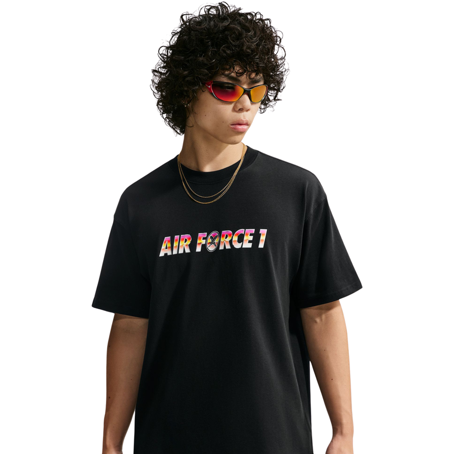 A model wearing a nike sb yuto horigome black t-shirt with 'AIR FORCE 1' printed across the chest in a colorful gradient pattern, styled with gold necklaces and red reflective sunglasses against a plain white background.