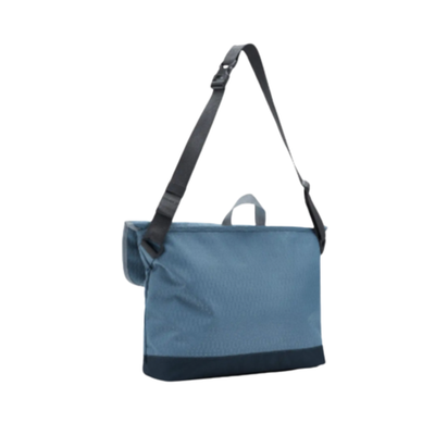 Blue herschel cove messenger bag with a black strap on a white background