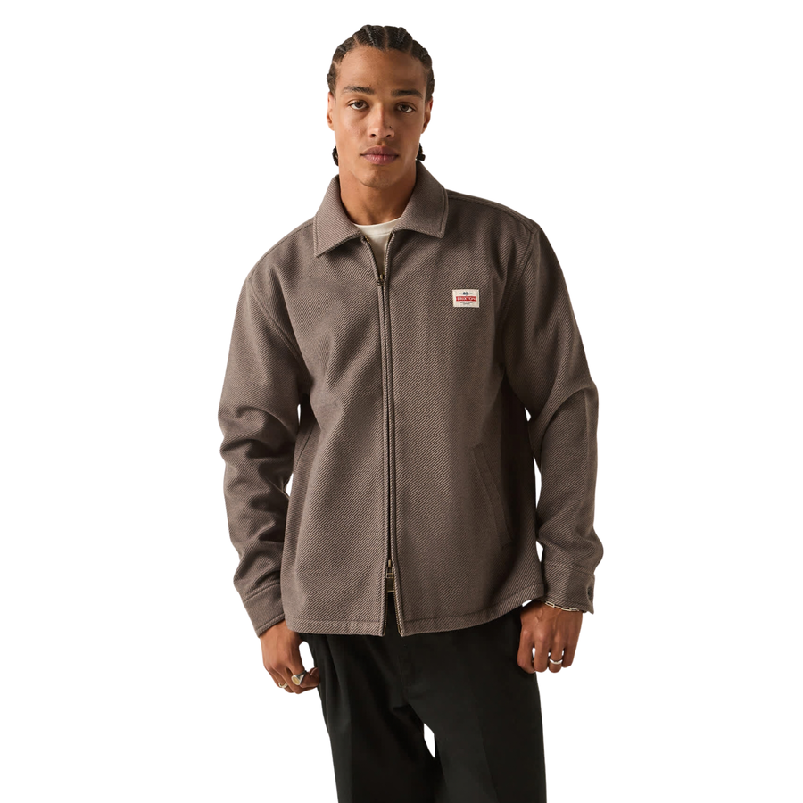 brown grey brixton trademark zip flannel jacket on a man in black pants on a white background