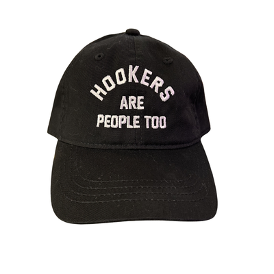 Black outdoor cap with 'HOOKERS ARE PEOPLE TOO' text on a white background