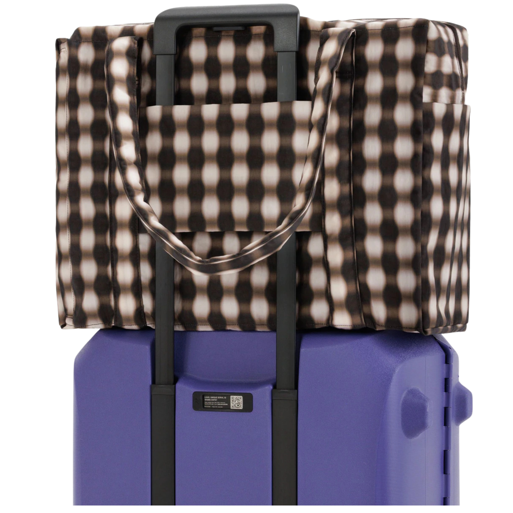 Checkered blanket draped over a purple suitcase on a white background