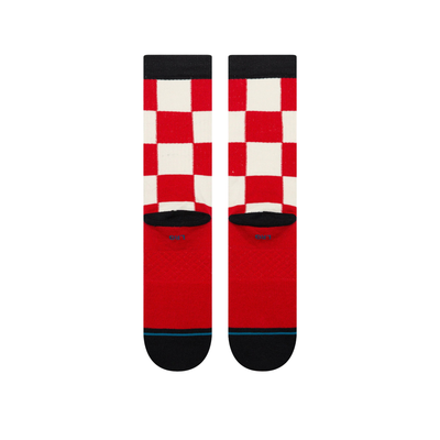 A pair of stance chaturanga crew socks with a red and white checkered pattern, featuring black cuffs, heels, and toes, and a small circular Stance logo on the side.