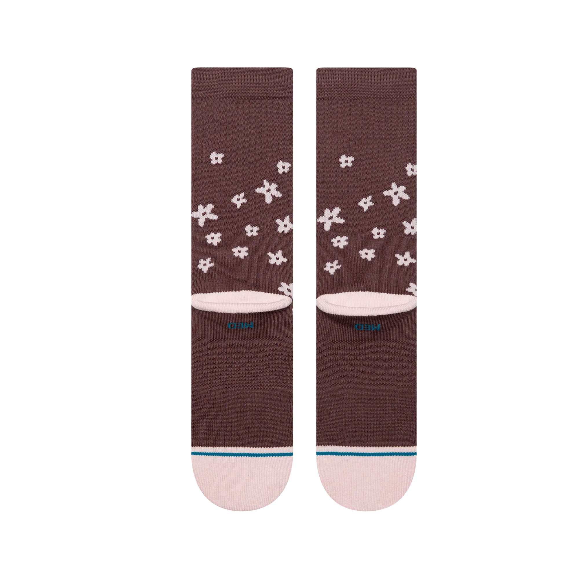 A pair of Stance crew socks in a dark brown color, featuring a white pixelated snowflake pattern and a light pink toe and heel, with the Stance brand logo visible on the side and toe.