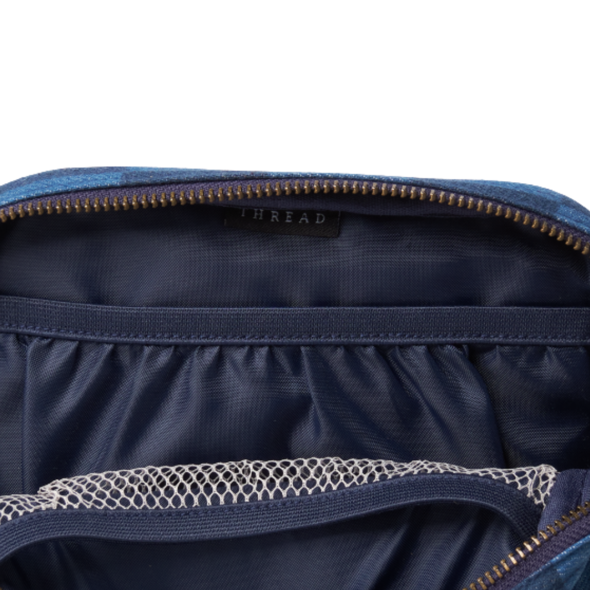 inside of a blue and navy checkerboard thread belt bag fanny pack on a white background
