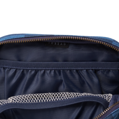 inside of a blue and navy checkerboard thread belt bag fanny pack on a white background