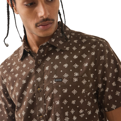 brown brixton men's charter print short sleeve woven button-up shirt with a bandana pattern on a man on a white background