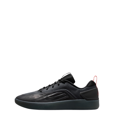 A black Nike nyjah 4 skateboard sneaker with a textured synthetic upper, black laces, a black sole, and a small red pull tab on the heel, shown from a side profile against a white background.