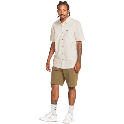 Man wearing a beige patterned volcom bankstone ii shirt on a white background