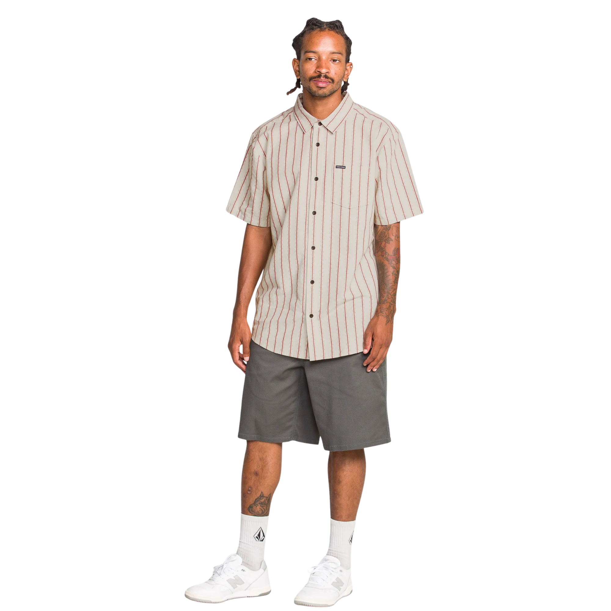 Man wearing a beige and red striped volcom sato stripe short sleeve shirt on a white background
