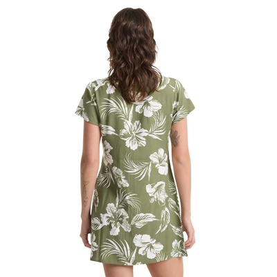 Woman wearing a green volcom vroom service dress with white floral pattern on a white background