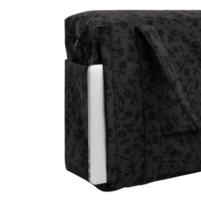 A black baggu cloud carry-on tote bag with a subtle tonal floral pattern, featuring two top handles and side pockets, shown against a plain white background.