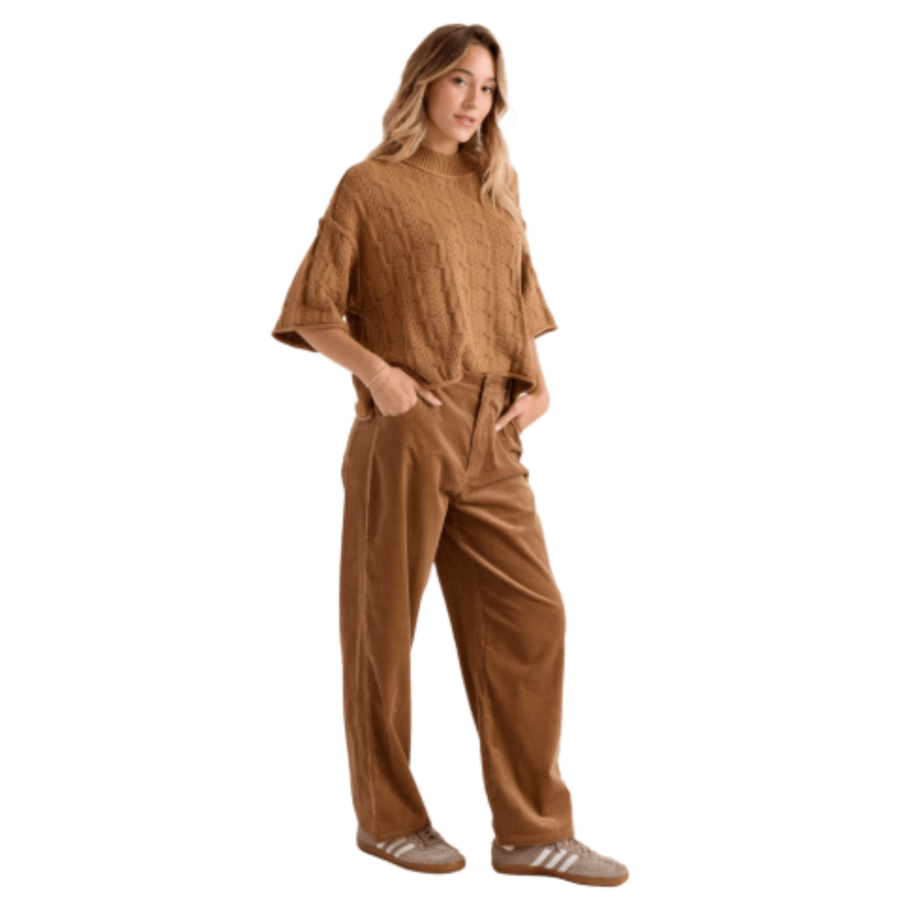 A woman wearing a brown volcom oversized cable-knit mock-neck sweater and matching brown corduroy pants, shown against a plain white background.