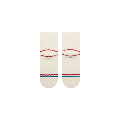 A pair of Stance crew socks in off-white, featuring a black circular logo with a white cross on the front ankle, a small red strawberry graphic on the side, and red and blue wavy stripe accents near the toe.