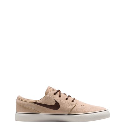 A Nike sb janoski low-top sneaker in a light beige suede and canvas mix, featuring a dark brown Swoosh logo, matching brown laces, and a thick white rubber sole.