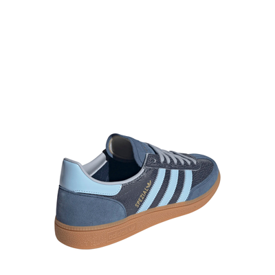 A single Adidas handball spezial sneaker in navy blue suede and textured leather, featuring light blue stripes, a light blue heel tab, and a brown gum sole, shown against a plain white background.