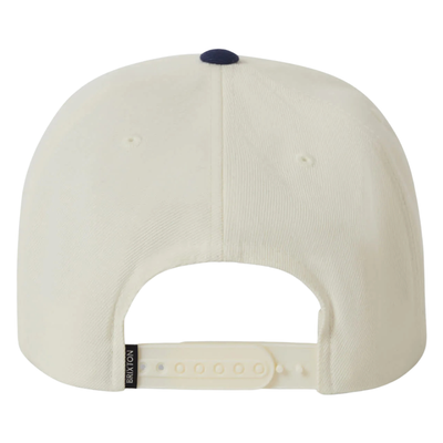 Beige and navy brixton snapback cap with a logo on a white background