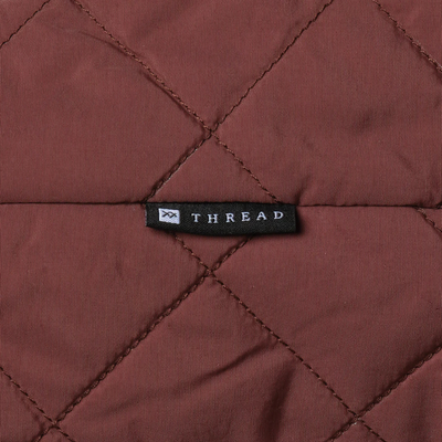 Brown quilted thread slouchy shoulder bag on a white background