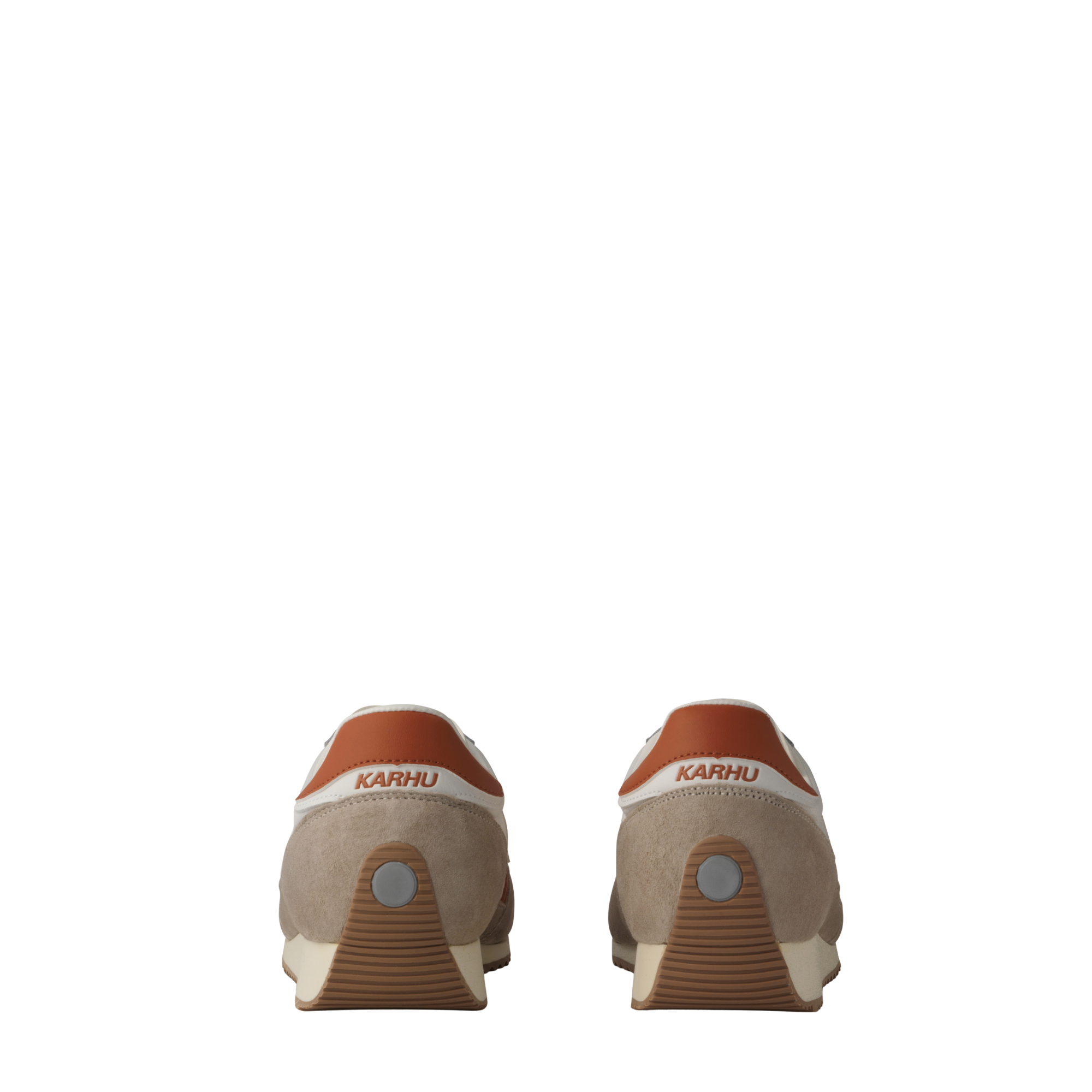 A low-top karhu mestari sneaker in beige suede and off-white leather with a prominent rust-orange 'M' logo on the side, a matching heel tab, and a beige midsole.