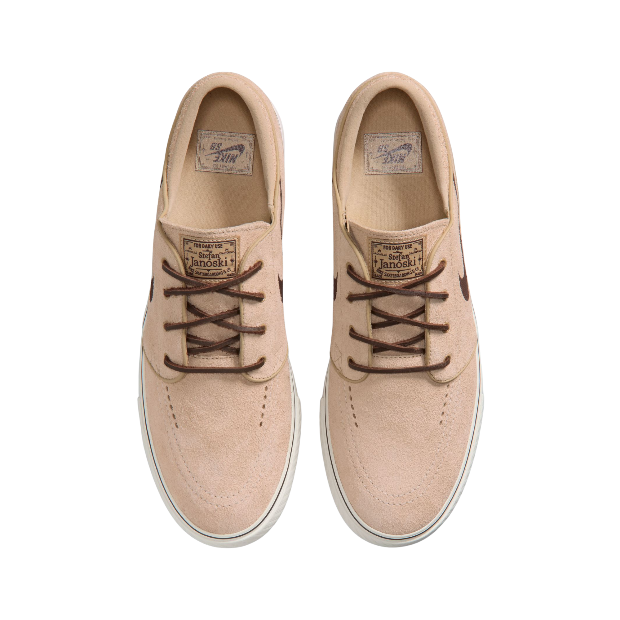 A Nike sb janoski low-top sneaker in a light beige suede and canvas mix, featuring a dark brown Swoosh logo, matching brown laces, and a thick white rubber sole.