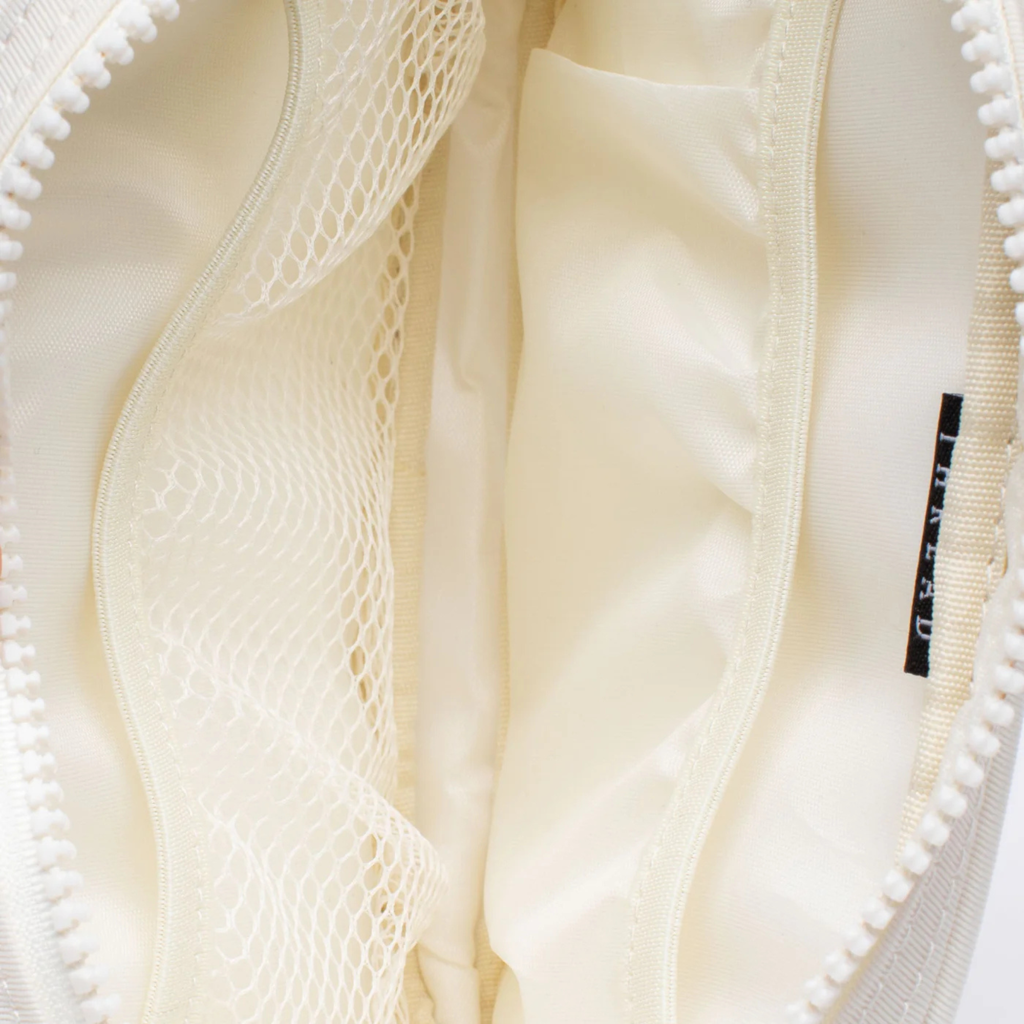 White thread waist bag with a small logo on a white background