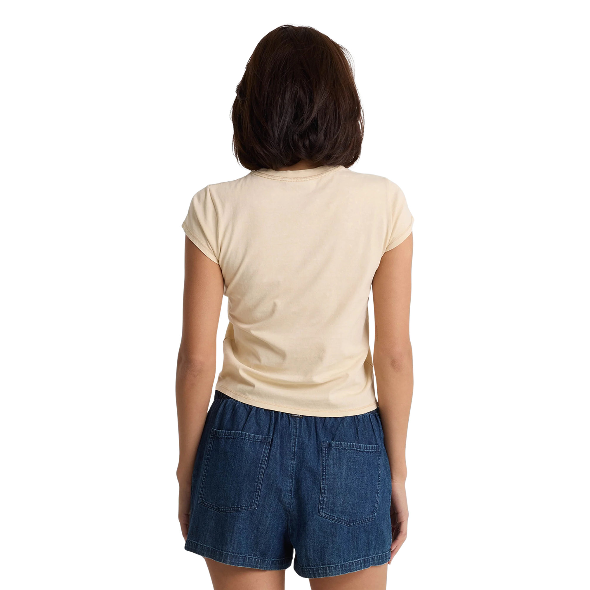 Woman wearing a beige volcom lived in stone wash t-shirt and blue shorts on a white background