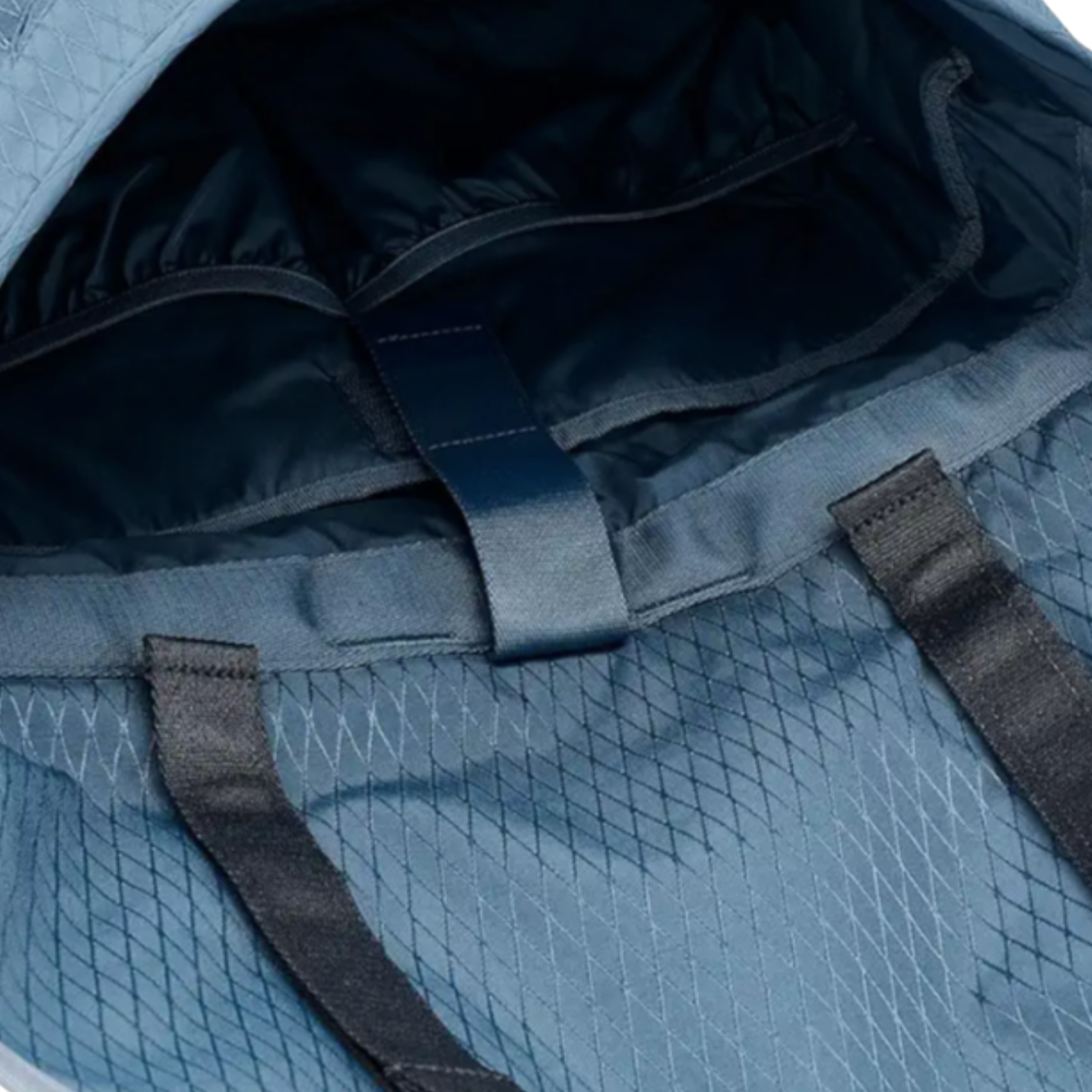 Blue herschel cove messenger bag with a black strap on a white background