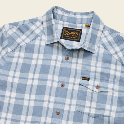A light blue and white plaid howler brothers la grange lightweight flannel long-sleeve button-up shirt with brown buttons, a chest pocket, and a visible brand label on the collar and chest pocket.